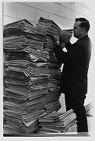 Man with a large stack of The Daily Reflector 
